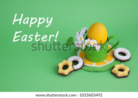 Easter decoration with eggs and watering can on a green background. 