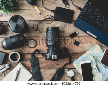 top view of work space photographer with digital camera, flash, cleaning kit, memory card, external harddisk, USB card reader and camera accessory on wooden table background