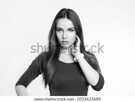 beautiful young woman with long brown hair posing on grey background wearing wrist watch