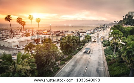 Aerial panoramic view of Ocean Ave freeway in Santa Monica beach at sunset - City streets of Los Angeles and California state surrounds - Warm twilight color filter tones with dark vignetting