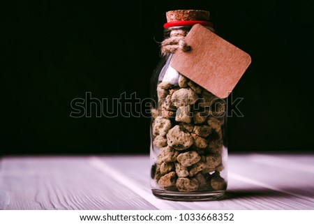 Decorative bottle with stones and label on wood