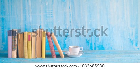 Row of old  books and a cup of coffee on a rustic table