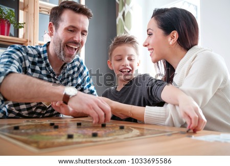 Happy family playing board game at home, happiness concept Royalty-Free Stock Photo #1033695586