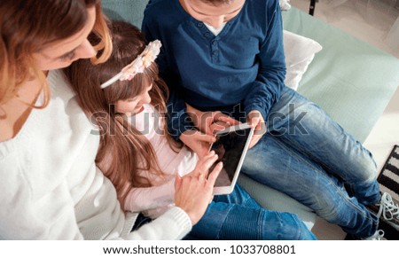 Happy modern family using together pc digital tablet at home