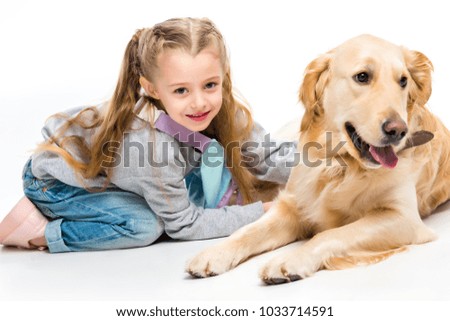 Closeup view of smiling little kid with lying beige dog isolated on white