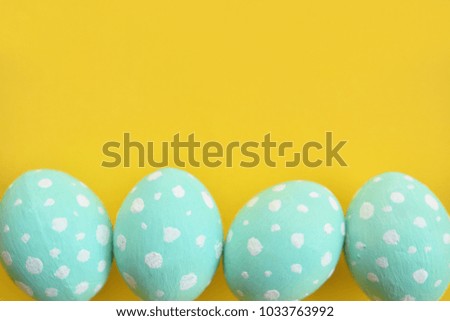 Easter eggs painted in pastel colors on a yellow background.
