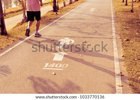 A healthy man jogging run on the running road and run sign in nation park.Outdoor exercise concept.
