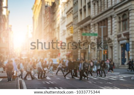 Anonymous crowd of people walking across the intersection in SoHo New York City