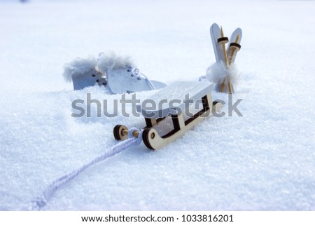 Decorations of ski with poles and a sleigh and skates on real snow.