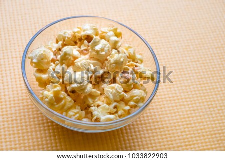 Full frame close-up bowl of popcorn on. : A glass bowl filled to the brim with delicious, nutritious popcorn.