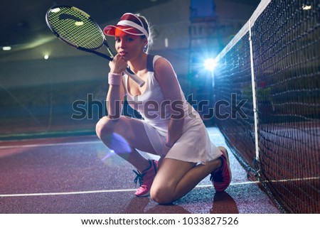 Full length backlit portrait of modern young woman posing in tennis court and looking at camera, copy space