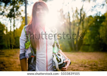 Image of young athlete with bicycle helmet at autumn forest