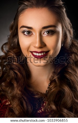 Charming young girl with beautiful curly hairstyle in studio