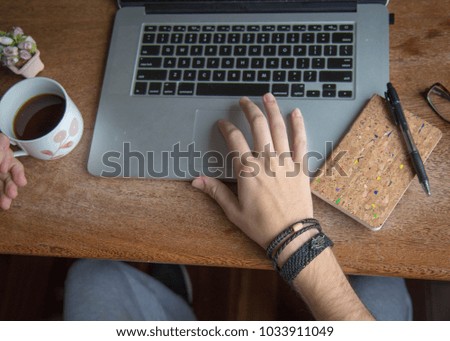 Vintage but modern author and writer, wooden laptop on desk. Male hands using a laptop and holding a cup of coffee. such scenes are good for authors, writers, editors or journalists