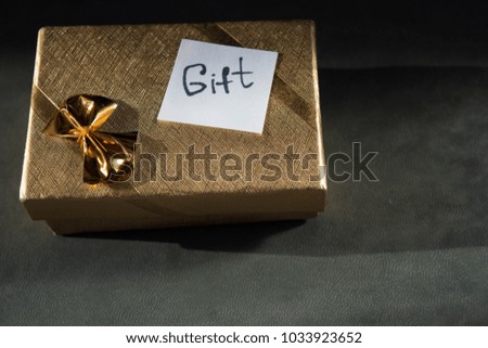 Gold gift box with inscription on paper