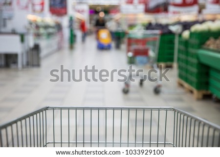 Trolley for products on supermarket background