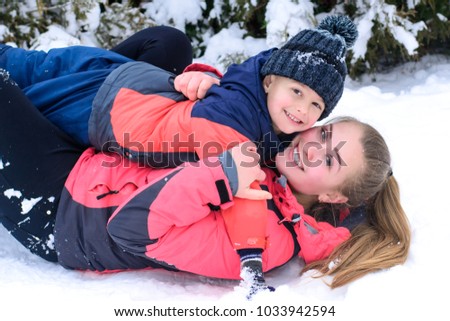 happy mother with her son embracing outdoors on the snow 