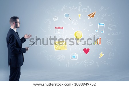 Young manager presenting new plan  illustrated by colourful chalk drawn icons and symbols around
