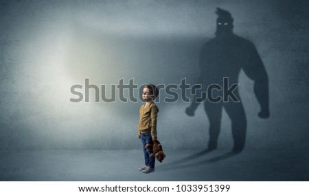 Cute kid in a room with plush on his hand and hero shadow on his background
