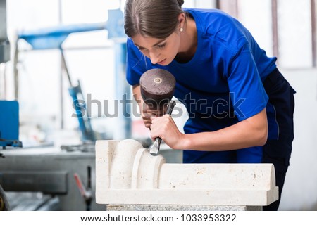 woman Stonemason carving pillar out of stone in her workshop Royalty-Free Stock Photo #1033953322