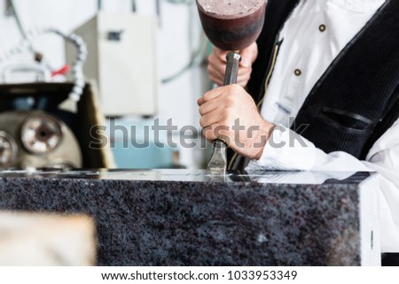 Stone mason working on tombstone in his workshop Royalty-Free Stock Photo #1033953349