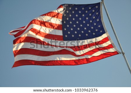U.S. flag on pole and blue sky
