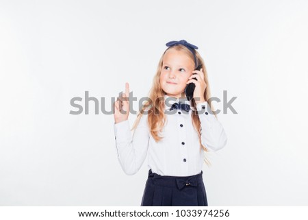 cute schoolgirl with long hair talking on a black phone isolated on a white background