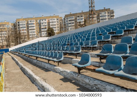 Industrial architecture shot with empty old stadium blue tribune.