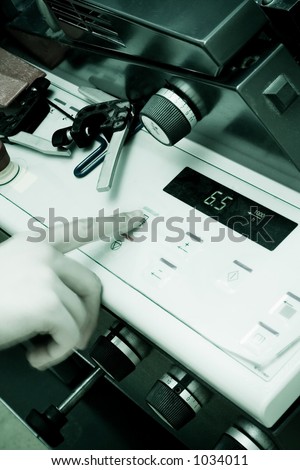 Operator pushing a button on an Offset Printing Machine in print shop