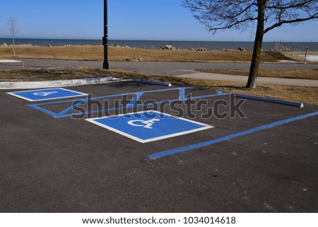 Two Disability or disabled restricted parking spaces painted on asphalt in a park along the shores of Lake Michigan in Racine, Wisconsin. 