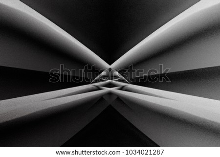 Abstract architecture with distortion effect. Angular girders refracted by small glass prism in center of composition. Contrast black and white photo of modern building in darkness.