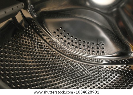Close-up of washing machine perforated stainless steel drum intended for automatic washing of clothes