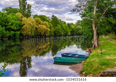 Valley of the river Dordogne two boats moored in the calm waters of the Dordogne in its passage through the village of Carennac France