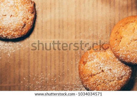 Closeup top view of round crunchy sweet biscuits with candied fruit and nuts, on textured parchment background, paper, flat lay, parchment