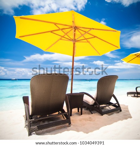 Sun umbrella and beach beds on tropical sandy beach, Tropical destinations Royalty-Free Stock Photo #1034049391
