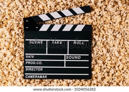 Movie clapper board and pop corn on background with copy space, top view. Movie time concept, close-up