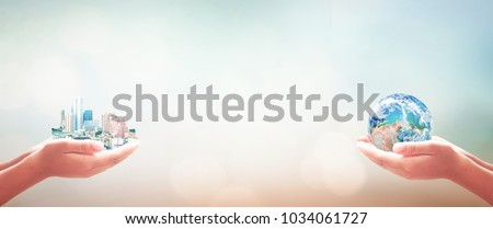 Corporate Social Responsibility (CSR) concept: Businessman and entrepreneurship hand holding big city and earth globe over blurred blue nature background. Elements of this image furnished by NASA Royalty-Free Stock Photo #1034061727
