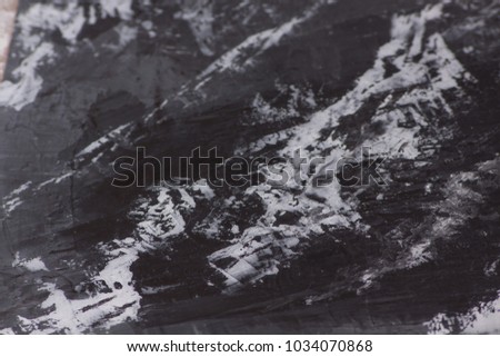 pattern of decorative plaster black marble with white streaks on black background with tools
