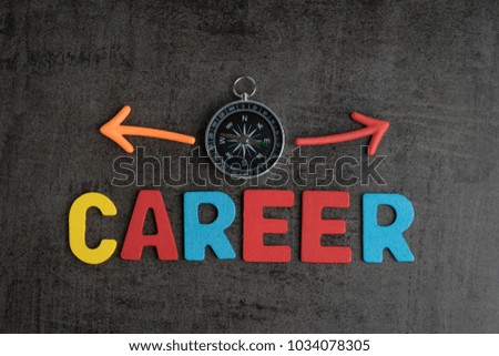 Company career path opportunities concept by colorful wooden alphabets as word CAREER and compass with magnet arrows pointing to left and right on dark black chalkboard cement wall.