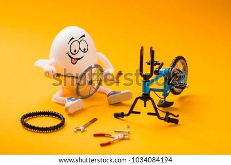 Funny egg repairing wheel of bike with various tools.