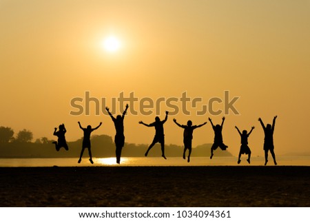 Boys happy jumping on sand in sunrise
