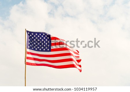 Close up Flag of United States of America (USA) waving in the wind with blue sky and cloudy