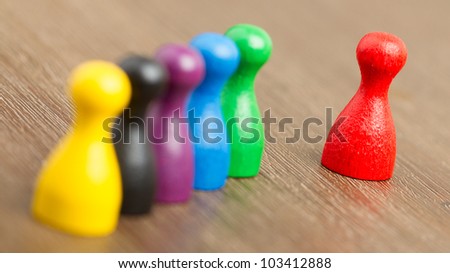 Six colored pawns isolated on a wooden background