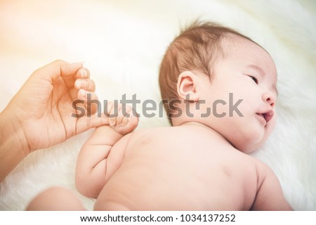 Baby sleeping in bed and hand holding his mom,Infant & Adult Finger Wrestling