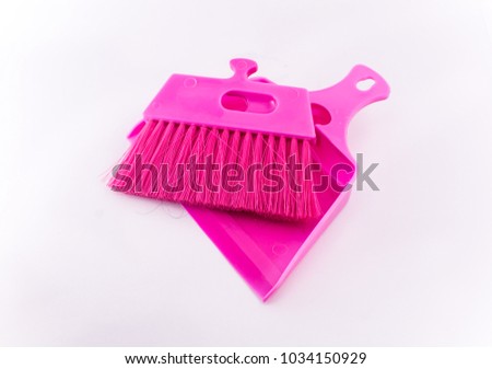 Small pink broom set on isolated white background. Selective focus