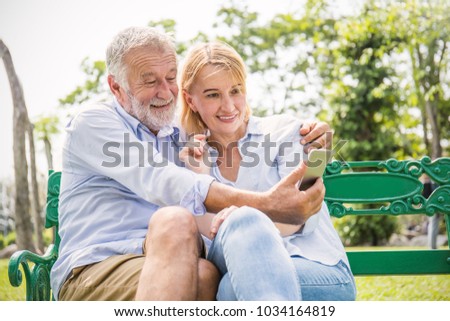 Senior caucasian couple take a self portrait together with smartphone. Closeup old mature man and woman selfie at the park. People lover lifestyle technology connection social online network concept