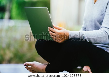 Close up woman sitting and using laptop computer outdoor as technology lifestyle of people