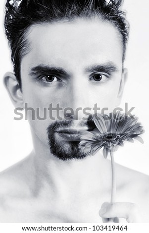 Portrait of a young man with gerberas in a hand close up