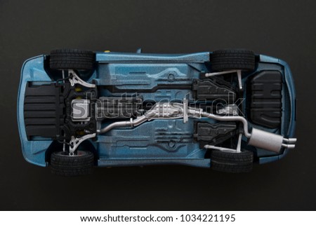 inverted car on a black background. bottom view of car
