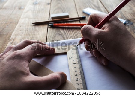 the men is makins a drawing on wooden background